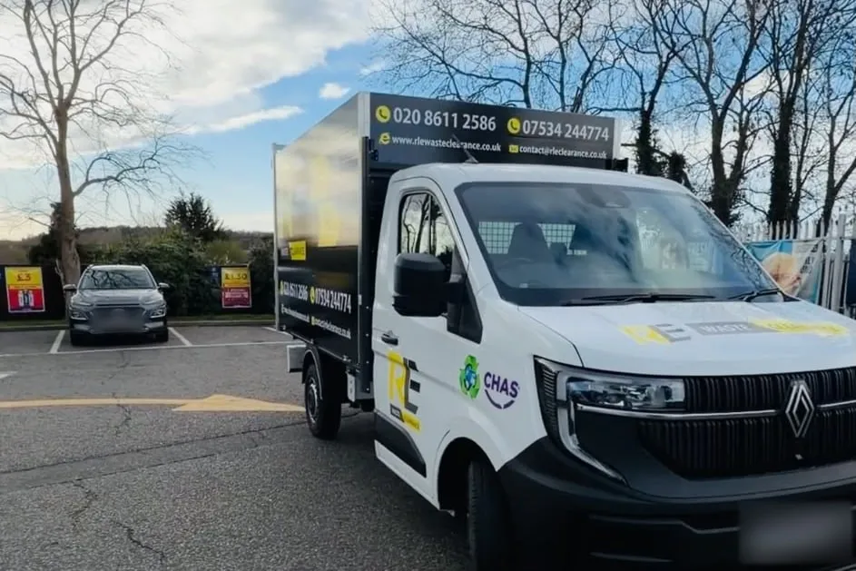 RLE Waste Clearance white tipper truck with a black cage and the CHAS logo on the door, parked in a car park